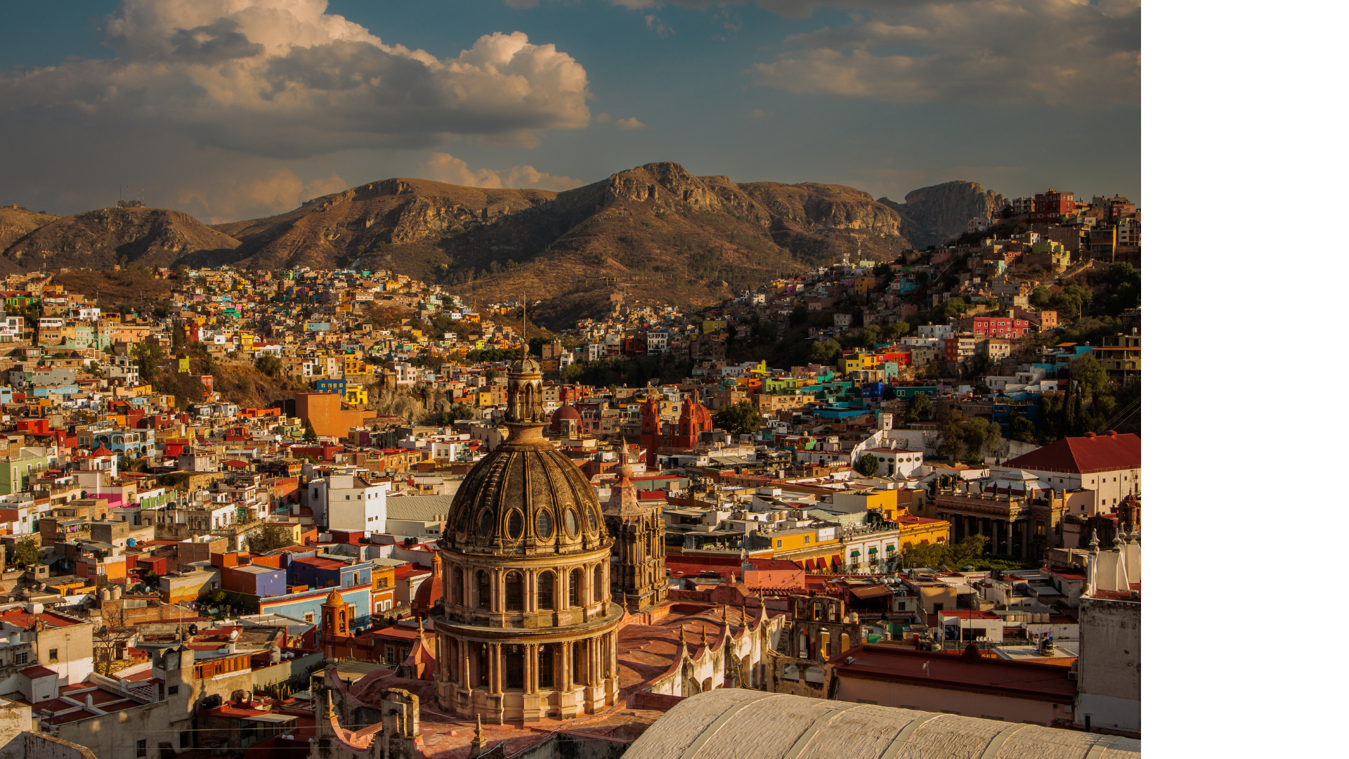 Colorful hillside houses and a domed basilica in Guanajuato, Mexico, at golden hour