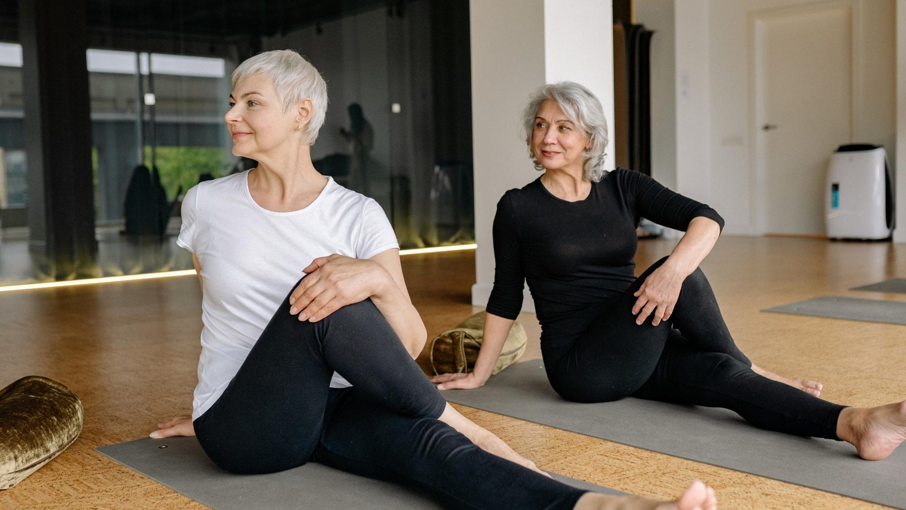 Two women stretching in a calm movement studio