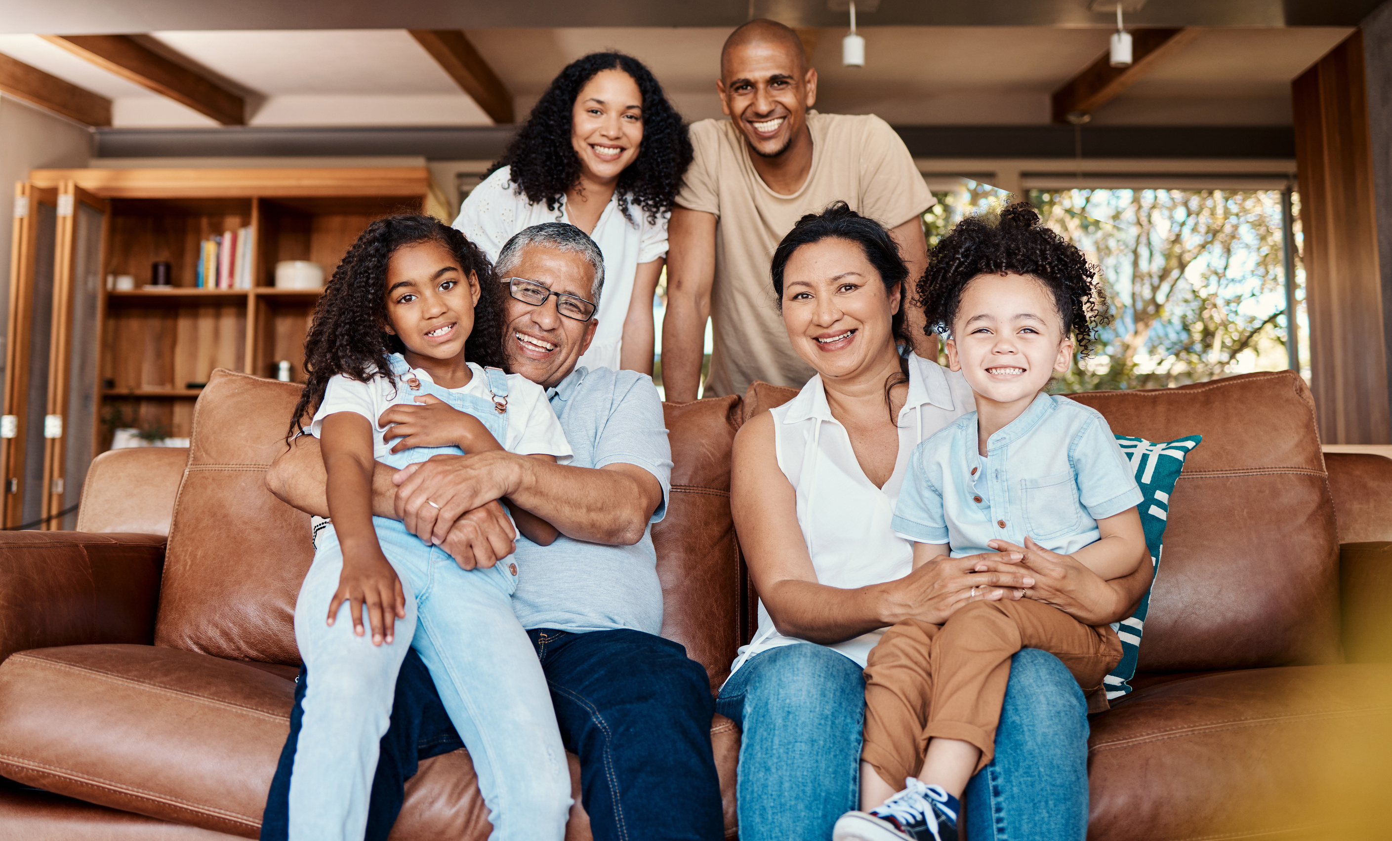 Three generations of a family gathered together on a sofa at home